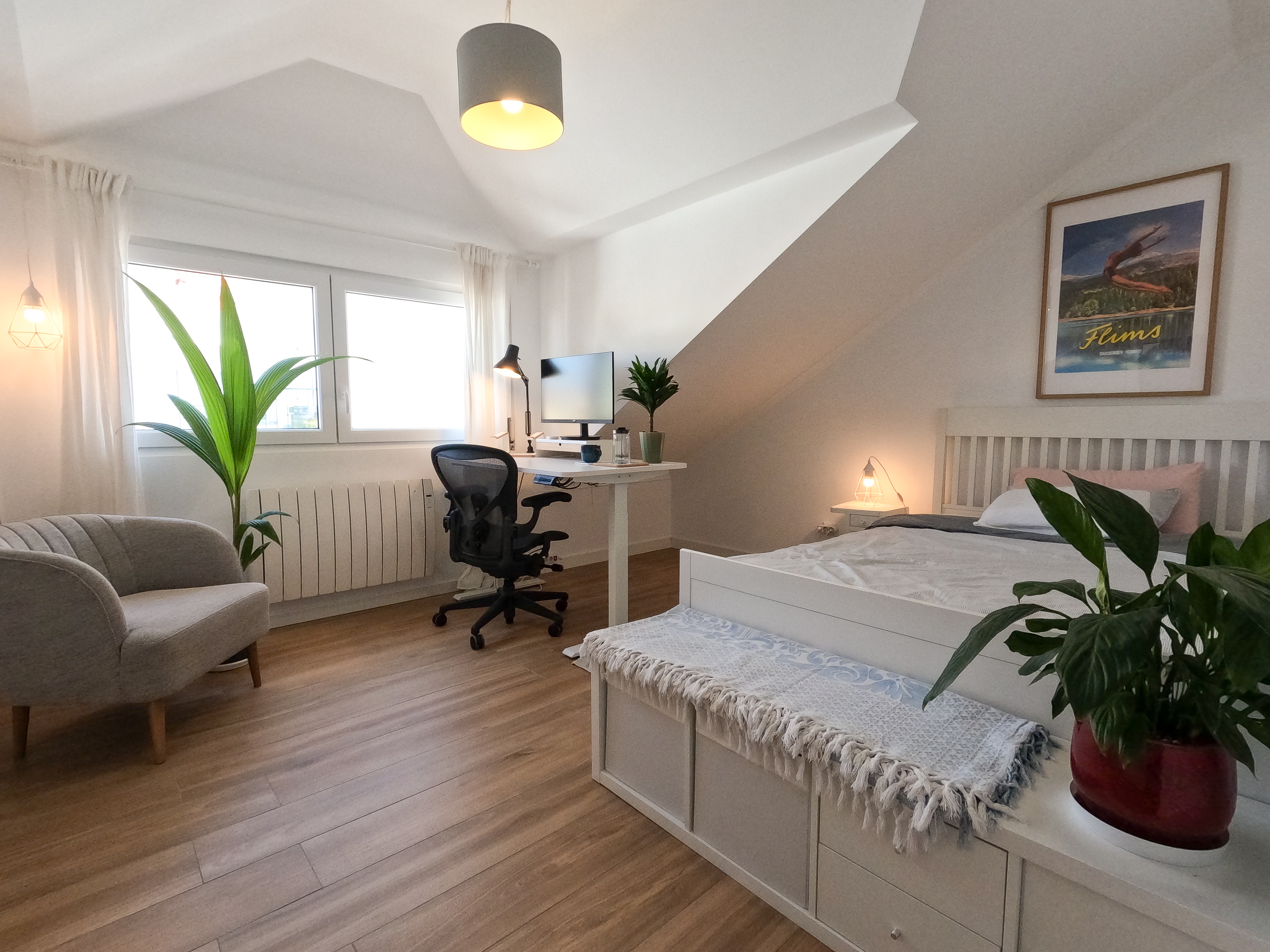 Spacious bedroom with ergonomic workspace, Herman Miller chair, and natural light