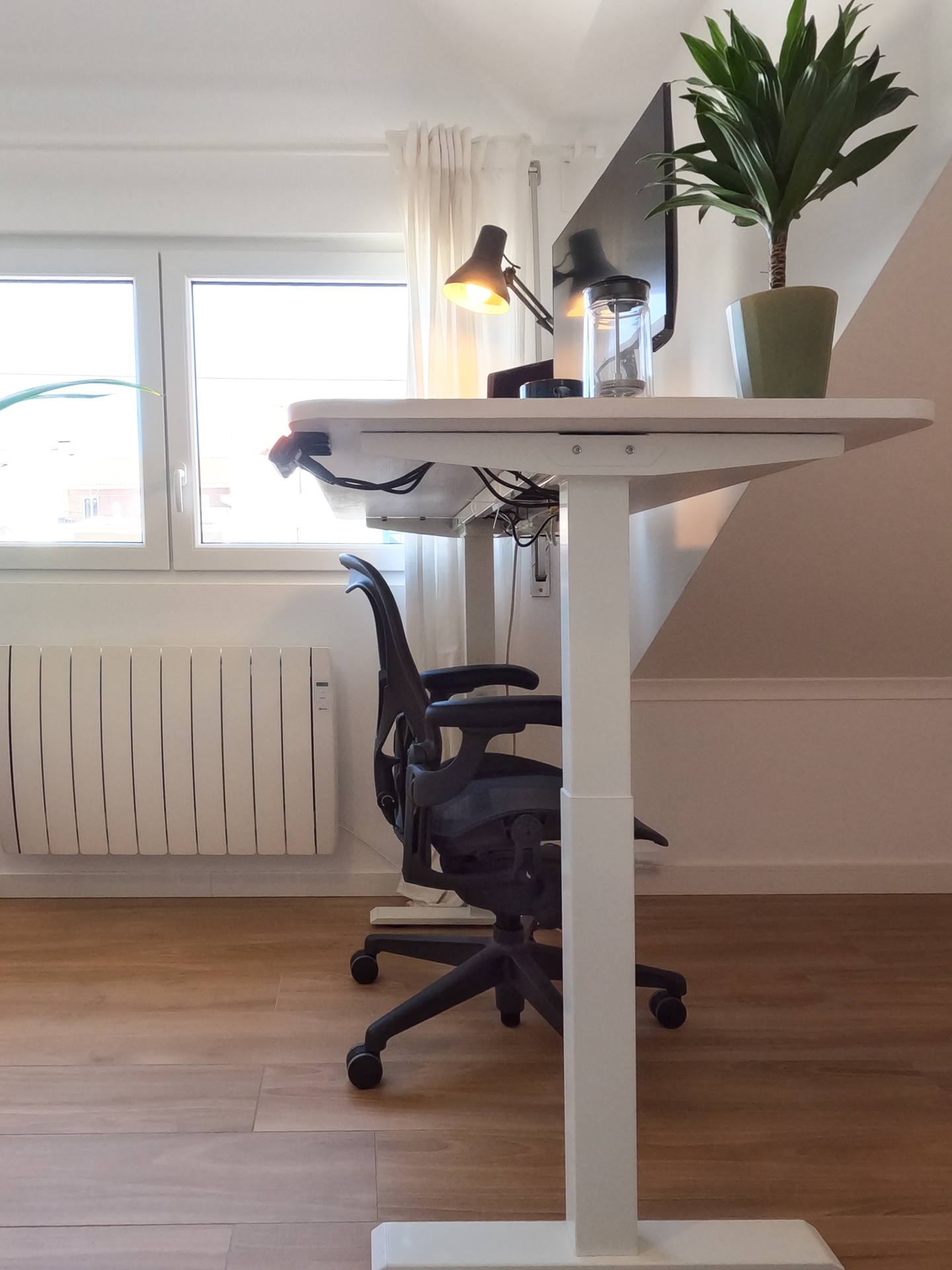 Adjustable standing desk side view with Herman Miller chair in attic room